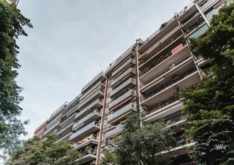 Prédio residencial com múltiplos andares em área urbana com presença de arborização e valorização imobiliária