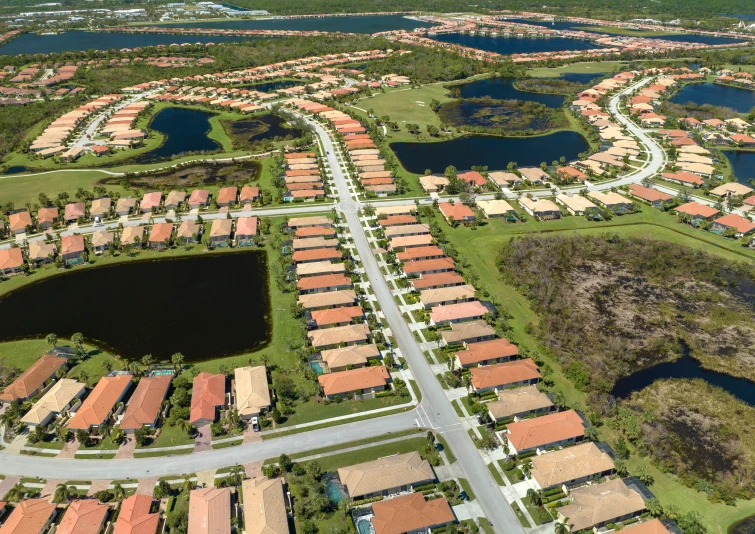 Vista aérea de bairro planejado com casas organizadas, vias estruturadas e áreas verdes valorizadas