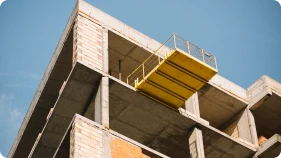Estrutura de prédio em construção com plataforma de trabalho destacando engenharia e execução de obra imobiliária